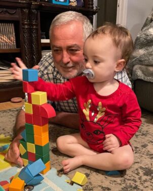 grandfather and baby playing with blocks