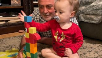 grandfather and baby playing with blocks